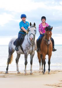 Two Friends Riding Their Horses on a Beach - Portrait Photograph