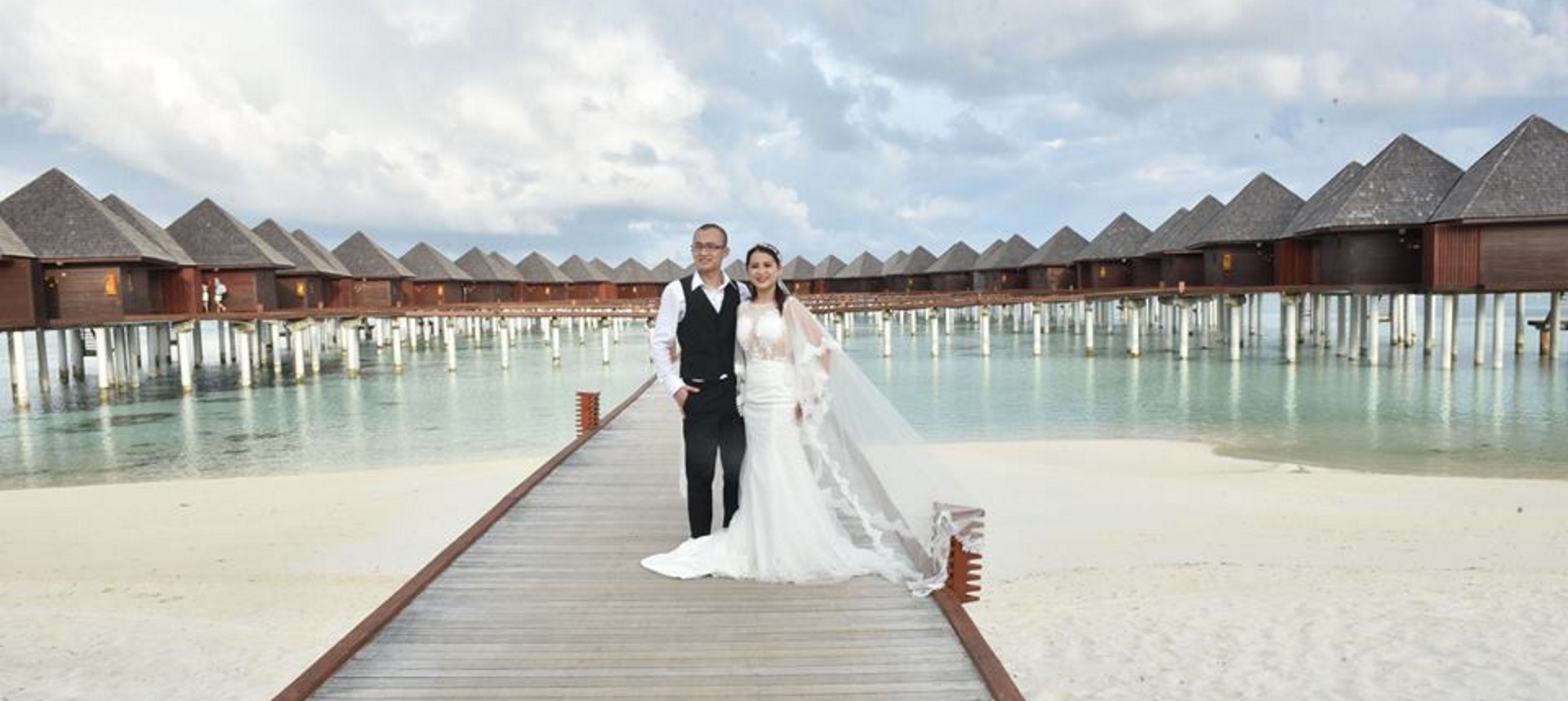 Wedding Photographers in Derby - International Wedding photogrpaher Package - Bride and Groom holding each others hand on pier and smiling.